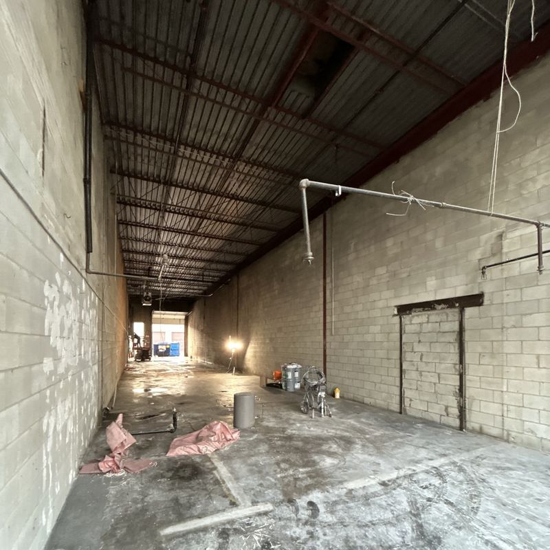 Warehouse unit before painting: stained, graffitied block walls